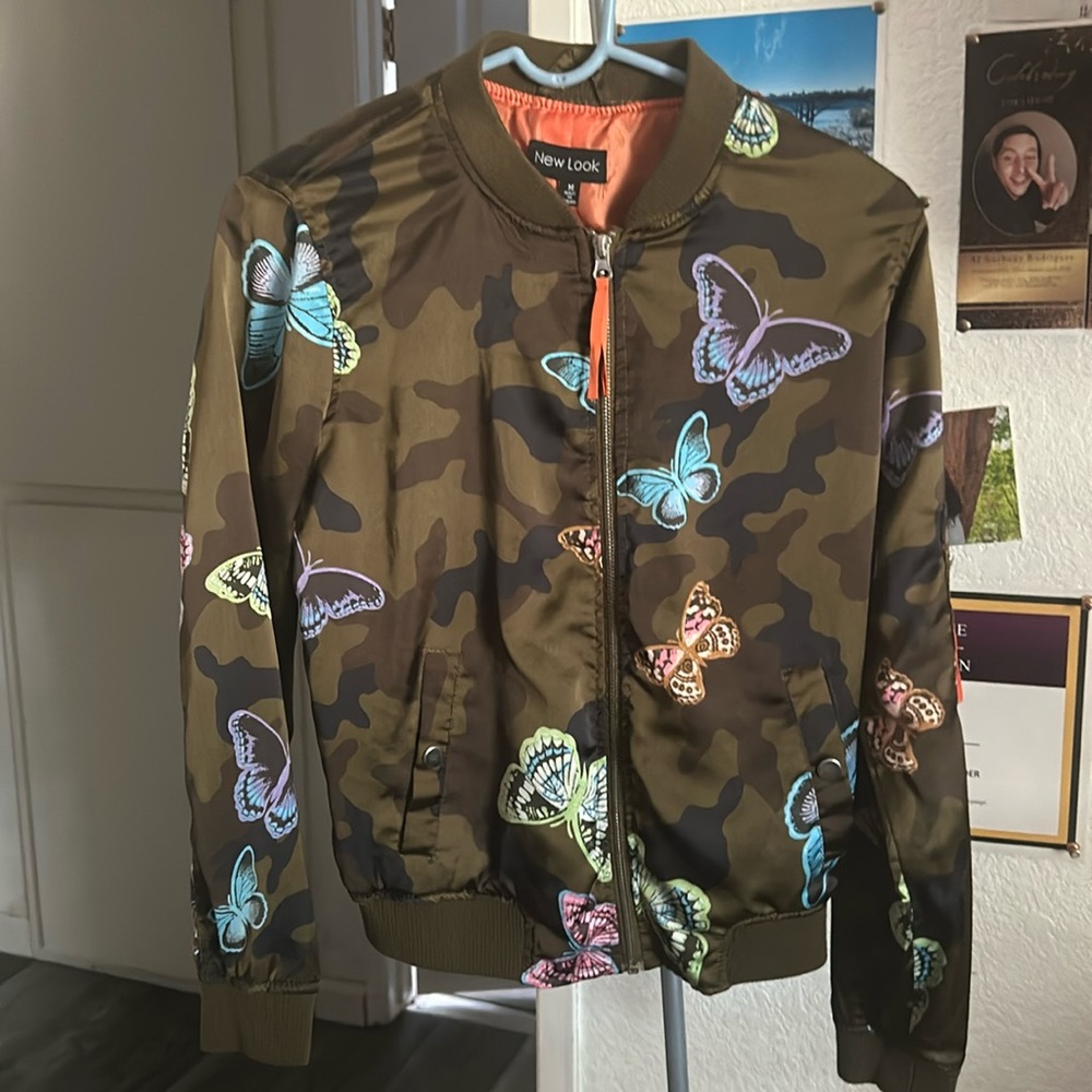 A camouflage coat with butterflies on them.